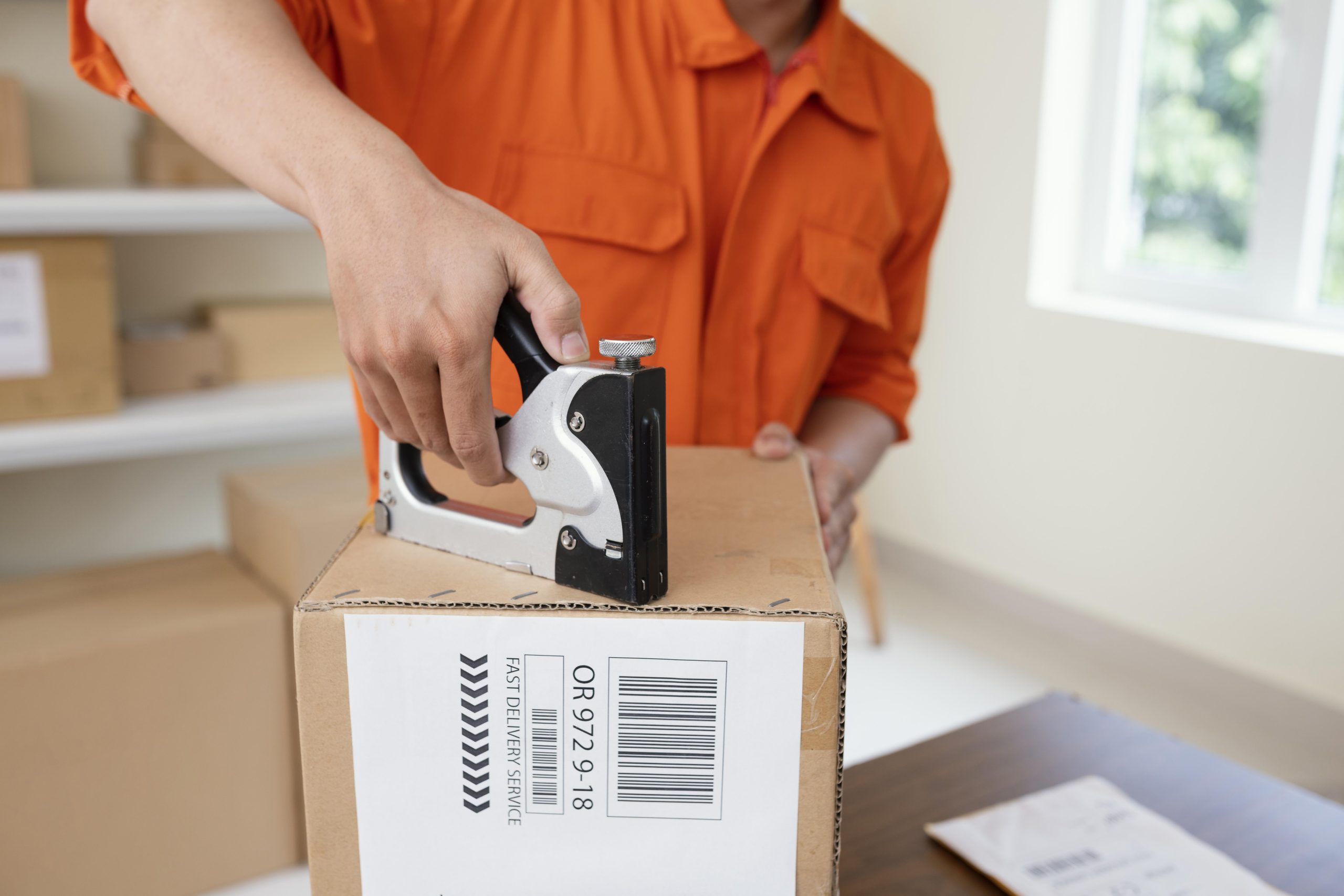 close-up-courier-preparing-package-delivery